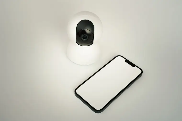 Indoor security camera next to a smartphone