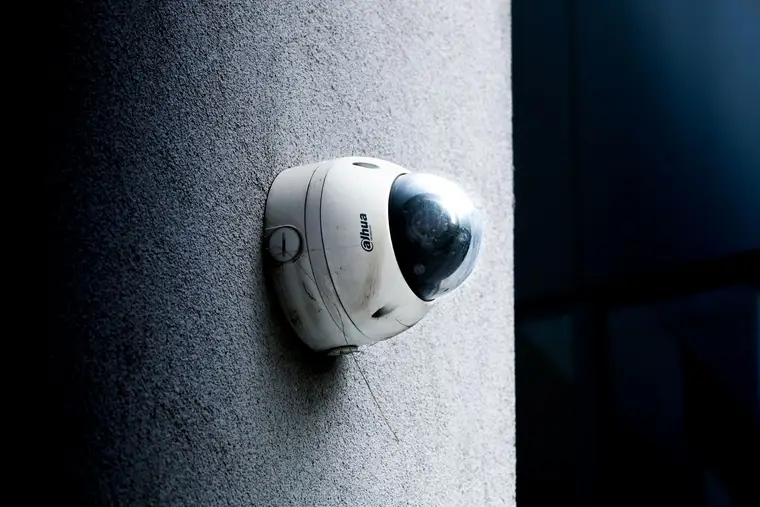 Dome security camera mounted on a gray exterior wall