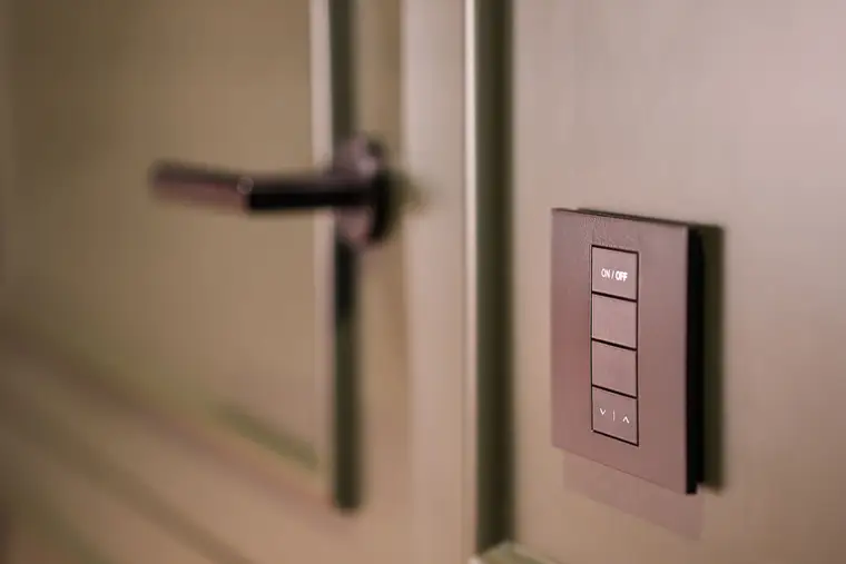 Smart light switch panel beside a door handle